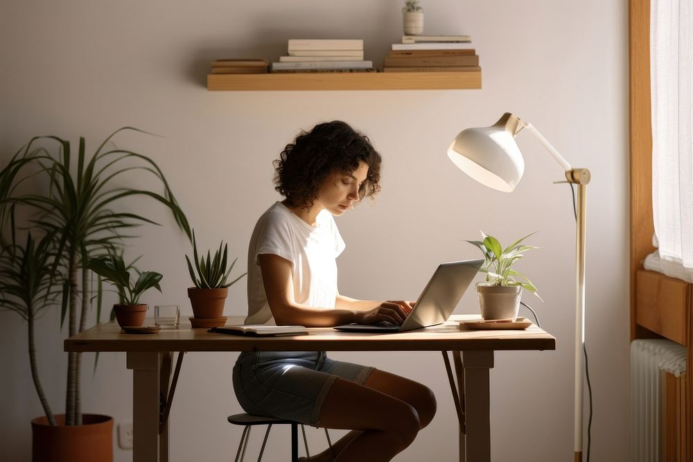 Young woman using tablet sitting desk furniture.