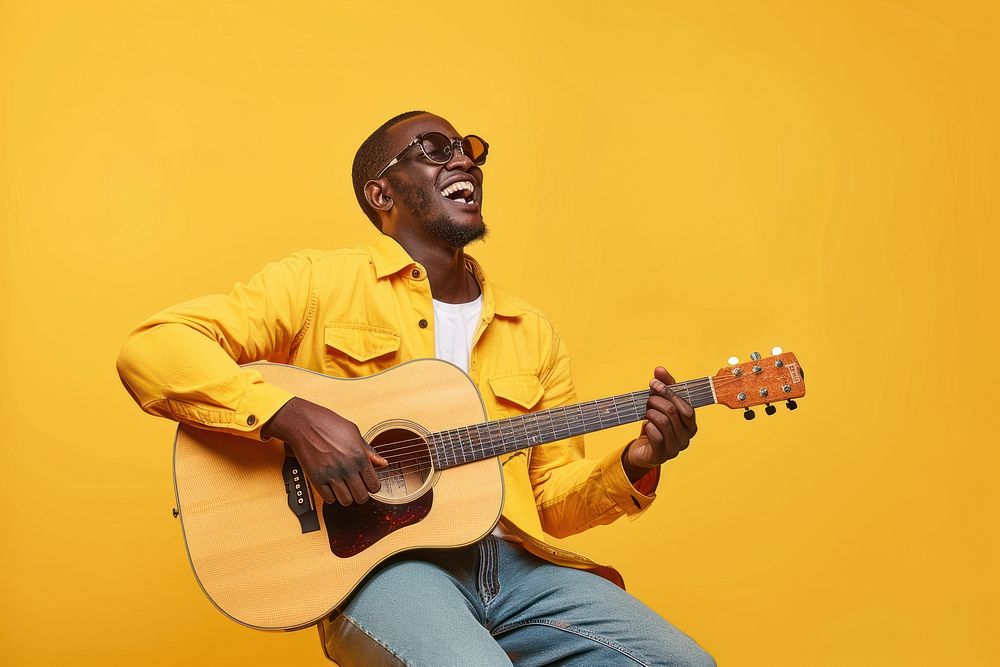 Man holds acoustic guitar and sings musician glasses yellow.