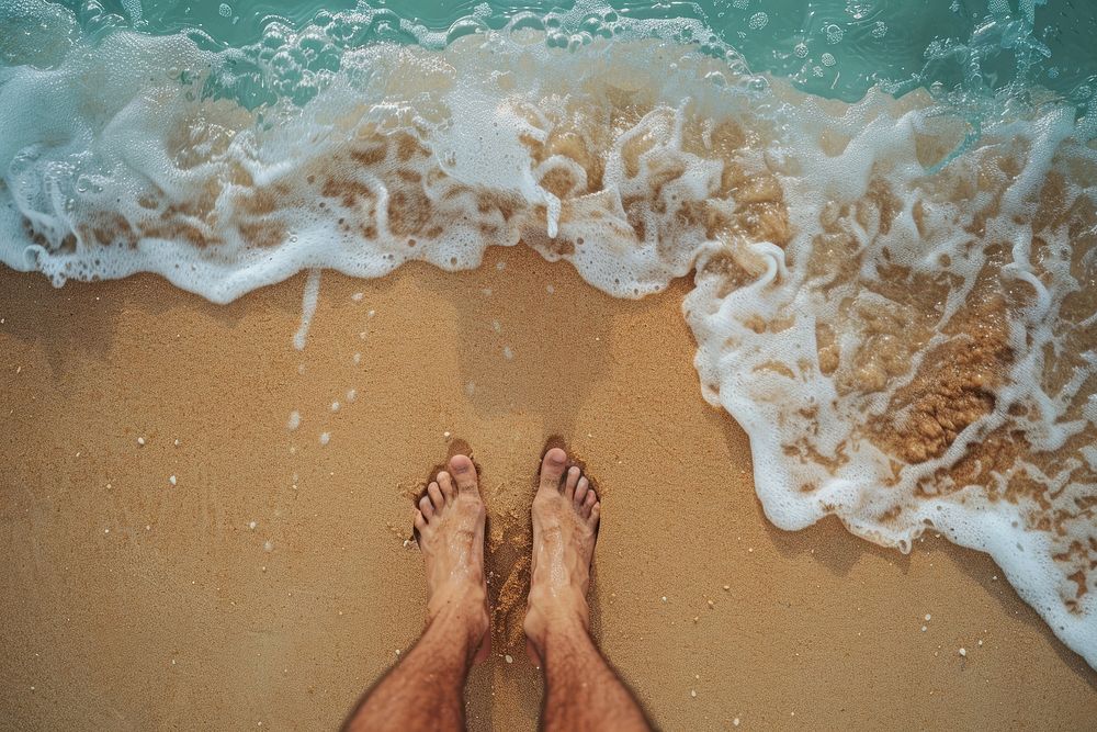 Man standing on beach sea barefoot outdoors.