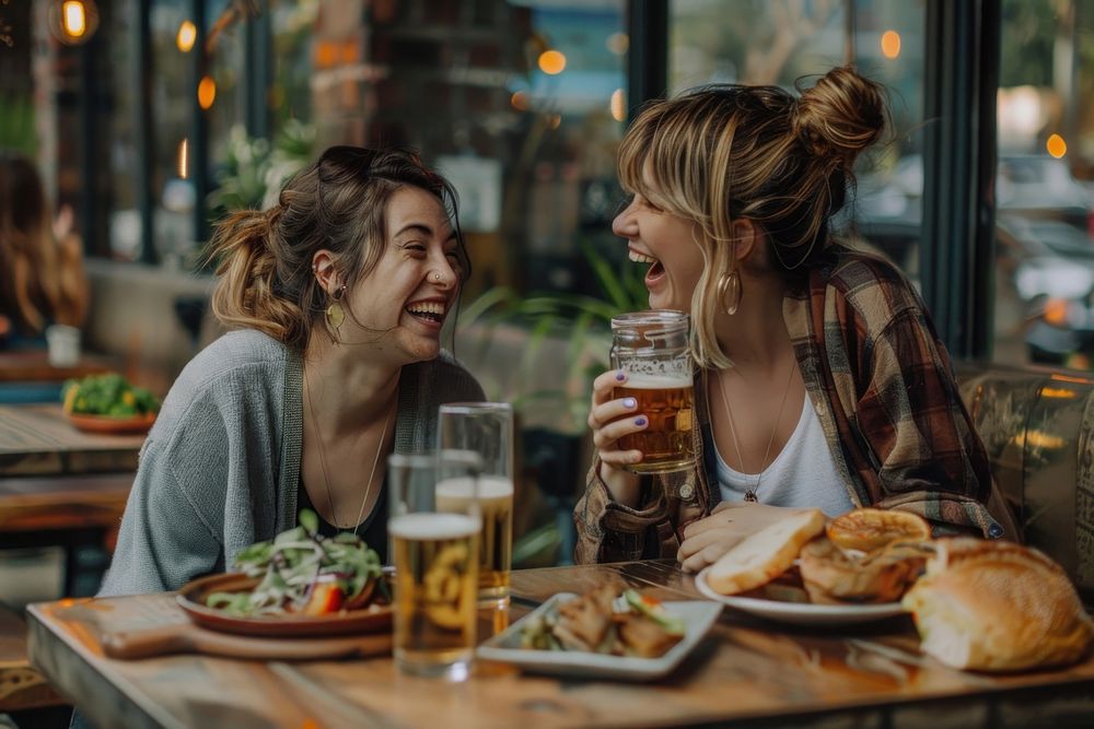 Two happy female having meal and beer and laughing drink bread adult.