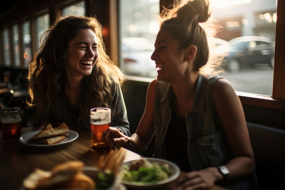 Two happy female having meal and beer and laughing photography portrait drink.