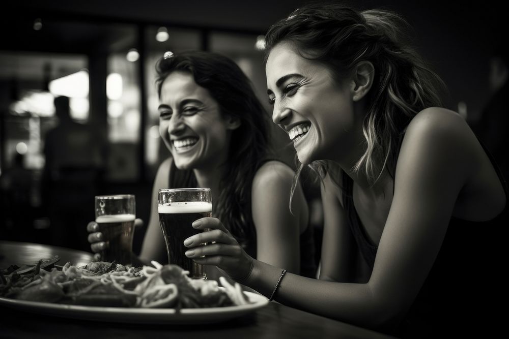 Two happy female having meal and beer and laughing photography portrait smile.