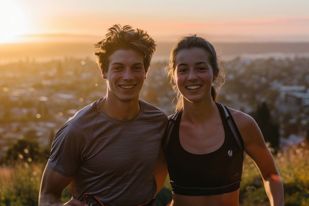 Fit young couple smiling while out for a run together on a scenic trail overlooking a city at sunset photography outdoors…