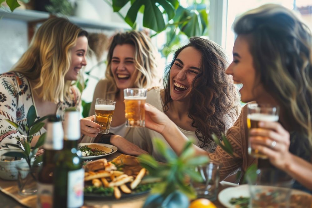Happy female friends having meal and beer and laughing drink party adult.