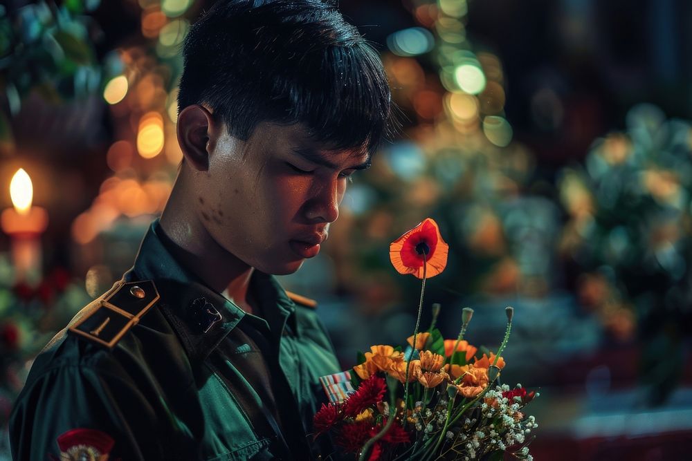 Thai soldier holding poppy crying at the Thai funeral blossom person flower.
