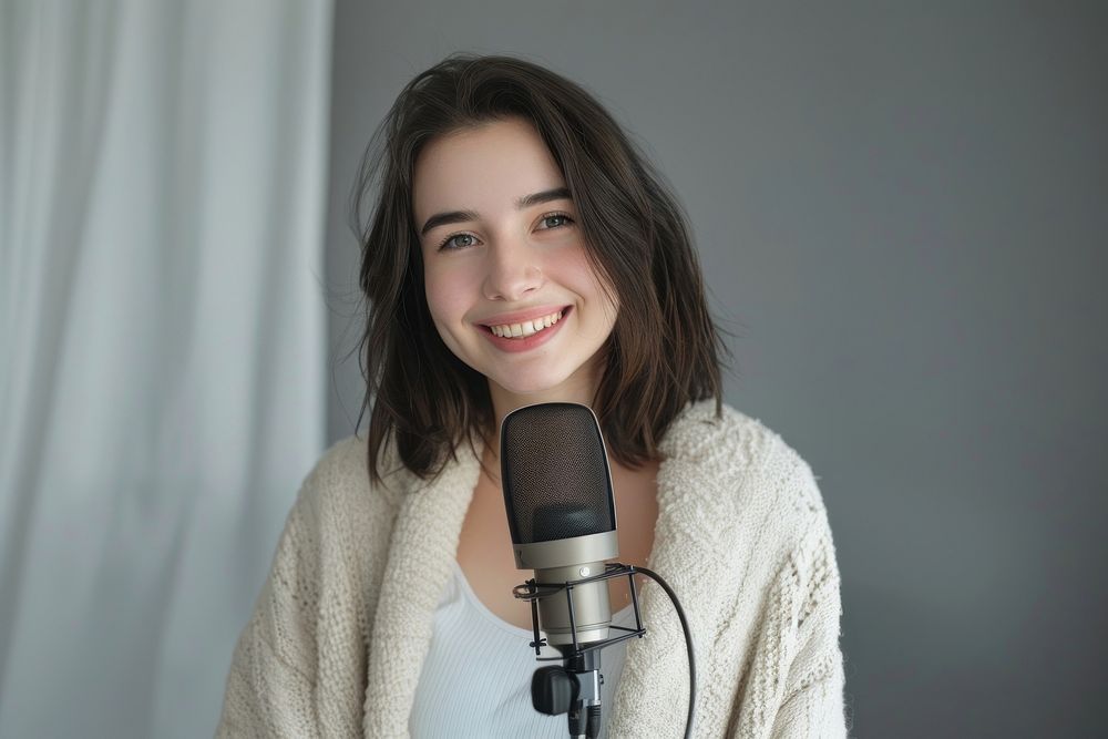 Smiling young woman recording podcast microphone performer clothing.
