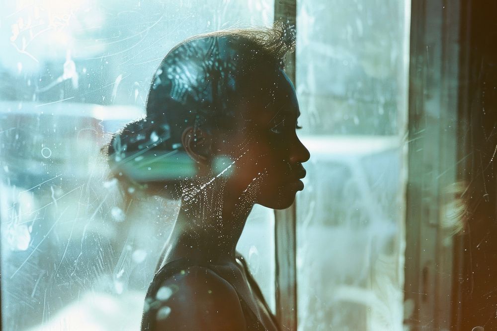 A black woman portrait standing at window side showering bathroom indoors.