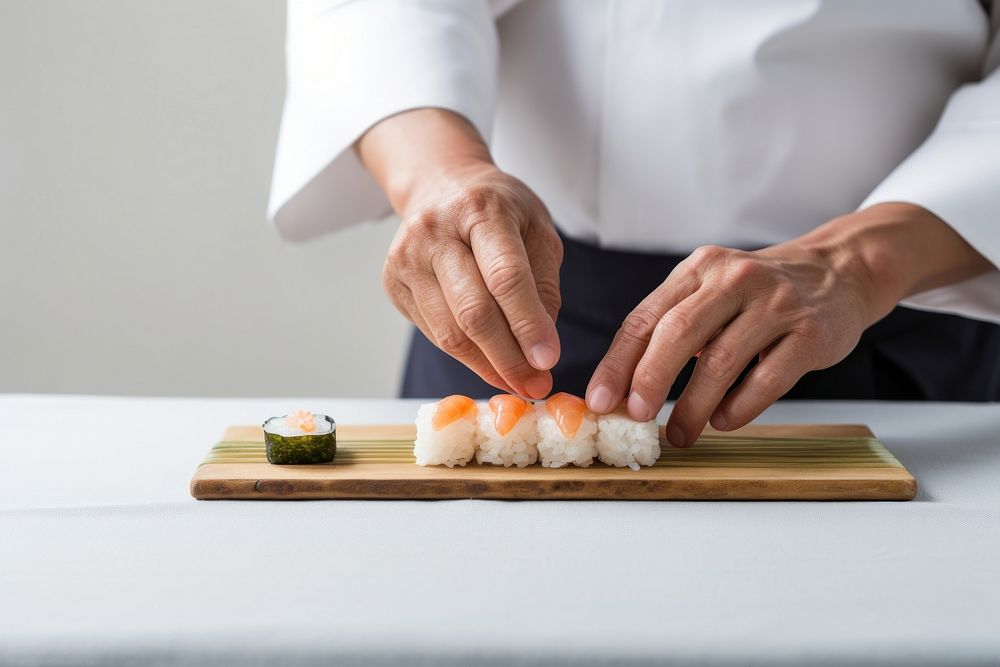 Japanese chef making small sushi produce grain food.