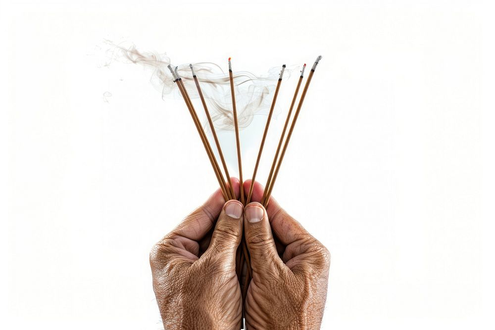 Hands praying with set of smoldering incense chopsticks weaponry finger.