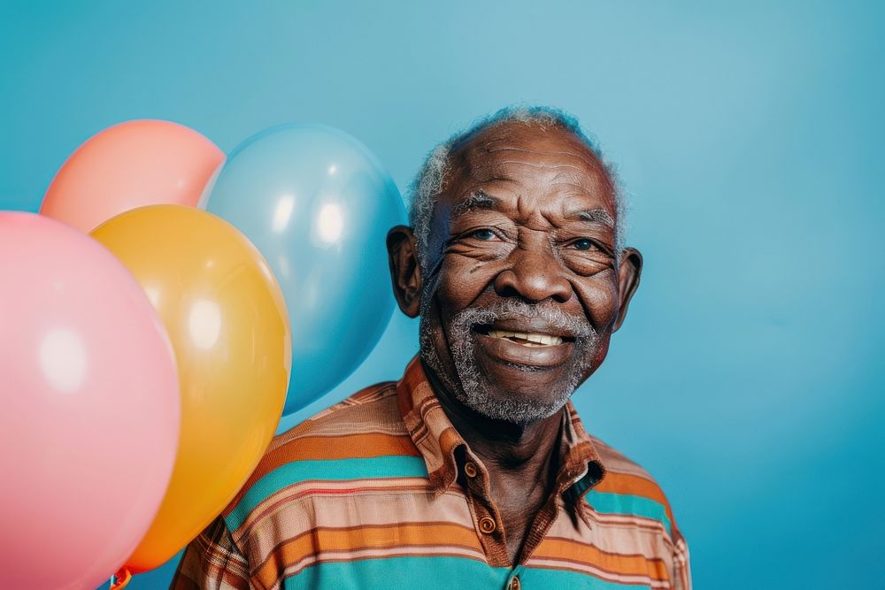 Lovely elderly African man holding balloons happy laughing dimples.