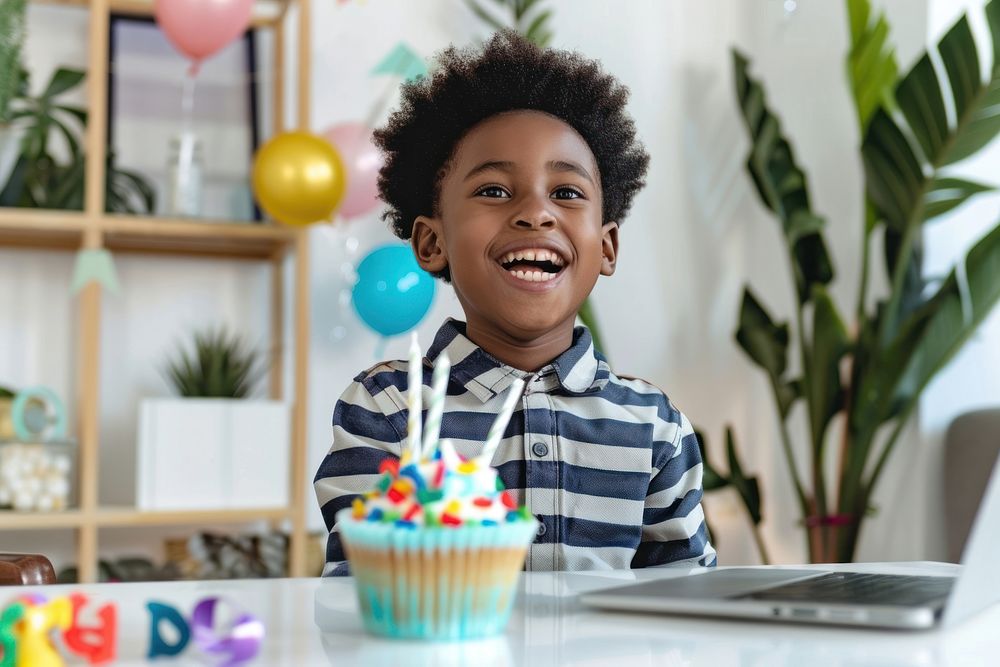 Laughing African kid celebrating his birthday laptop electronics computer.