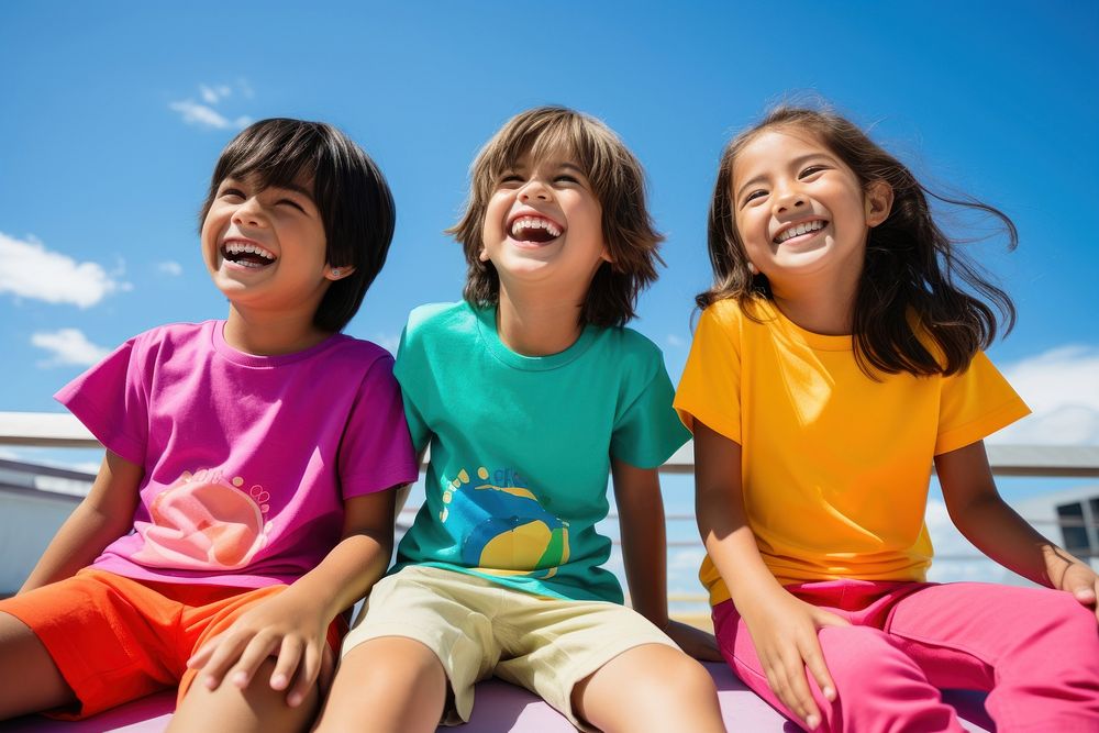 South east asian kids sitting together laughing clothing apparel.