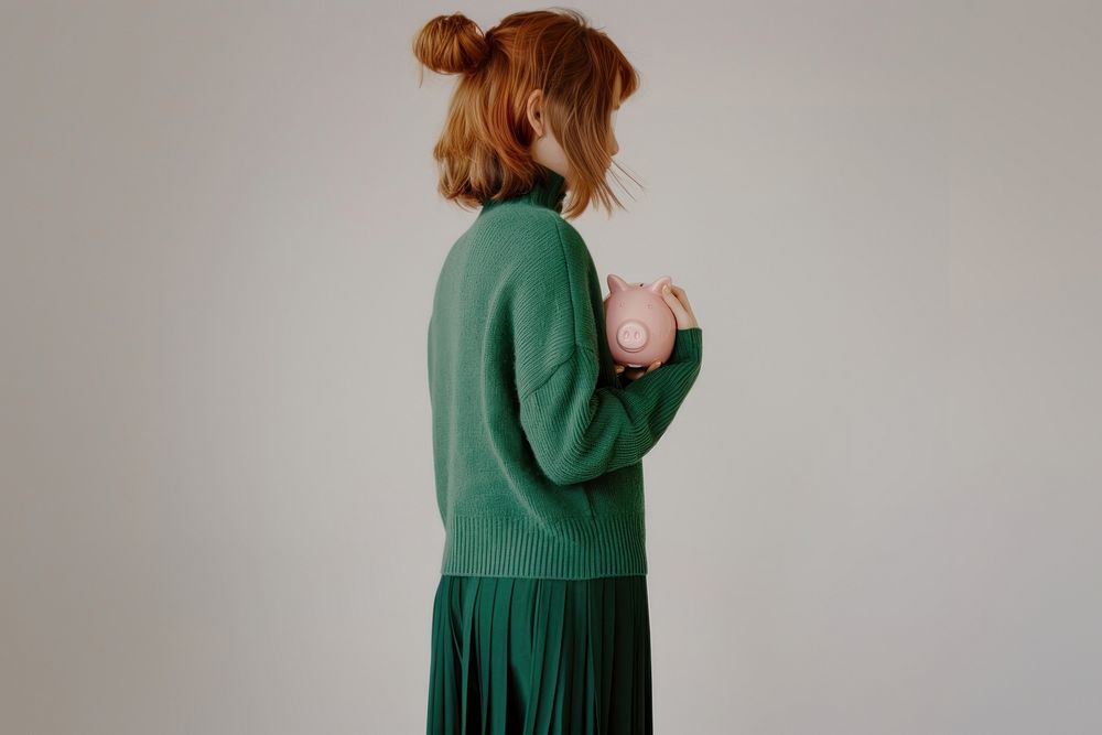 Girl hold piggy bank portrait sweater photo.