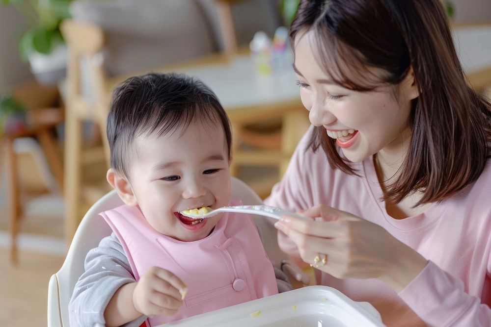 Asian mother feeding her baby spoon cutlery person.