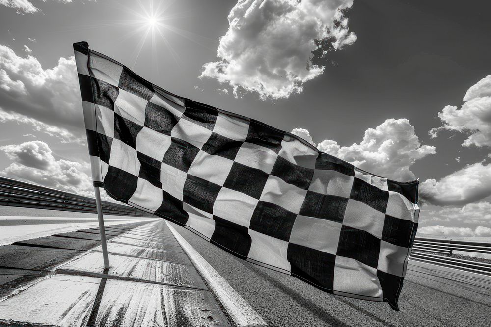 Checkered black and white flag on the wind asphalt tarmac road.