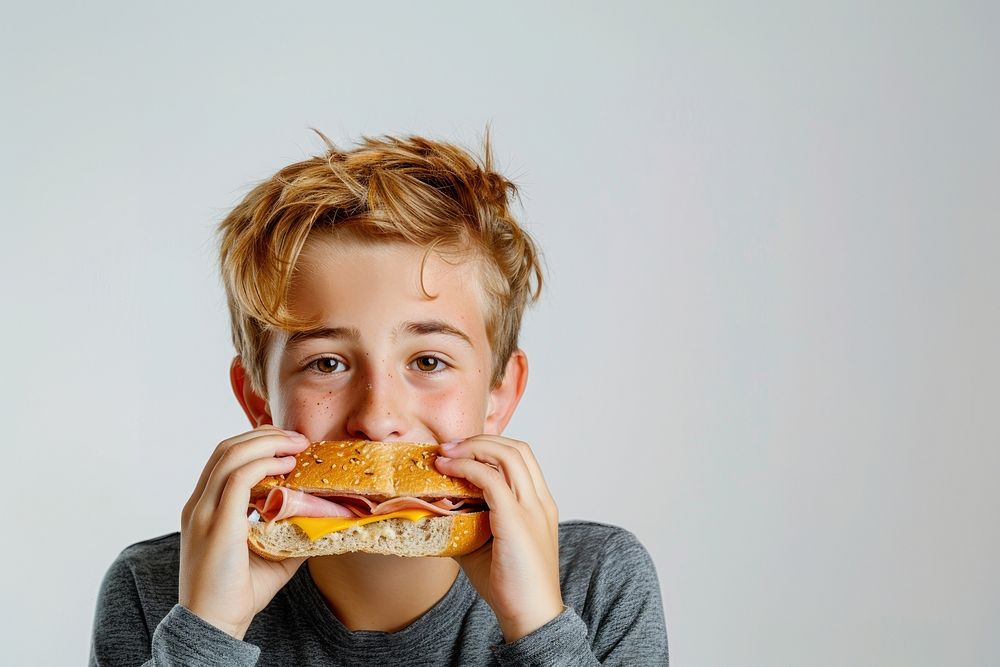 Teenage boy eating ham cheese sandwich person burger biting.