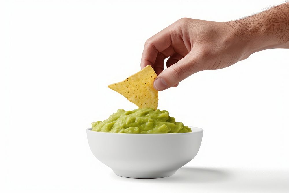 Finger dipping chip in guacamole bowl person human food.