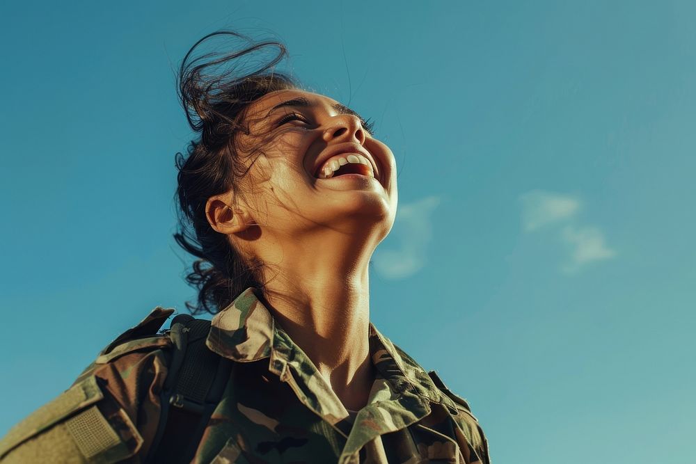 A woman soldier smiling laughing military clothing.