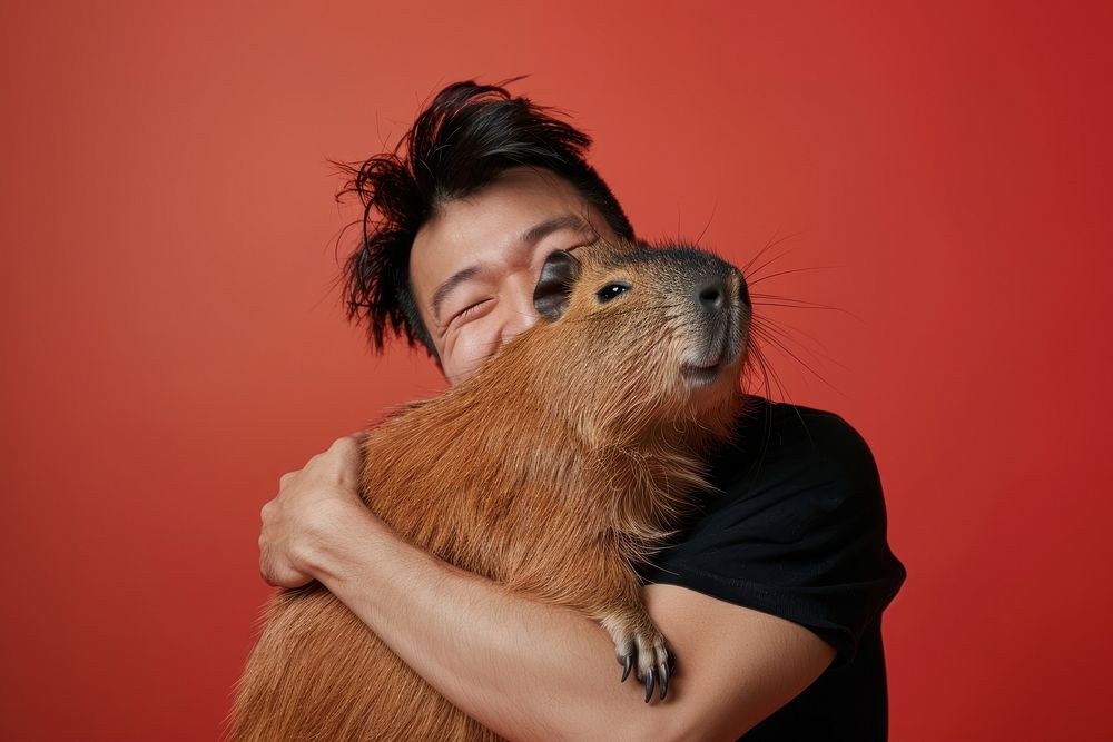 Asian man hugging capybara person animal mammal.