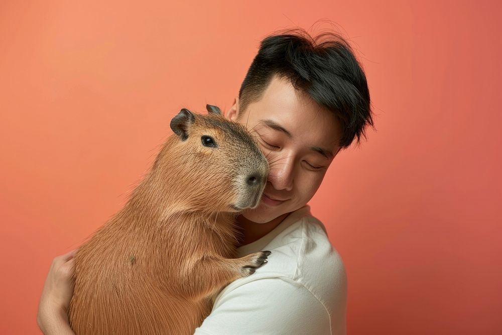 Asian man hugging capybara person female animal.