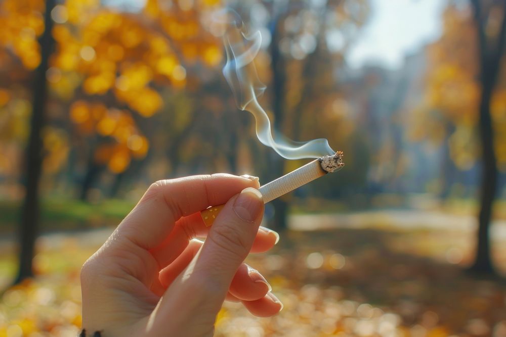 Photo of hand holding lightened cigarette smoking person human.