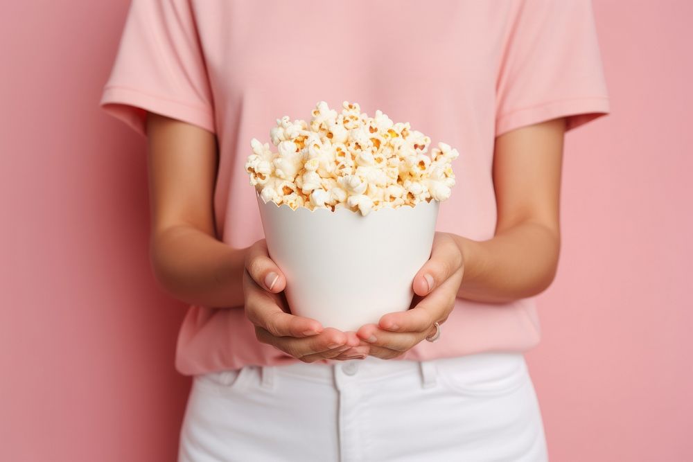 Photo of women holding popcorn on pink background adult food midsection.