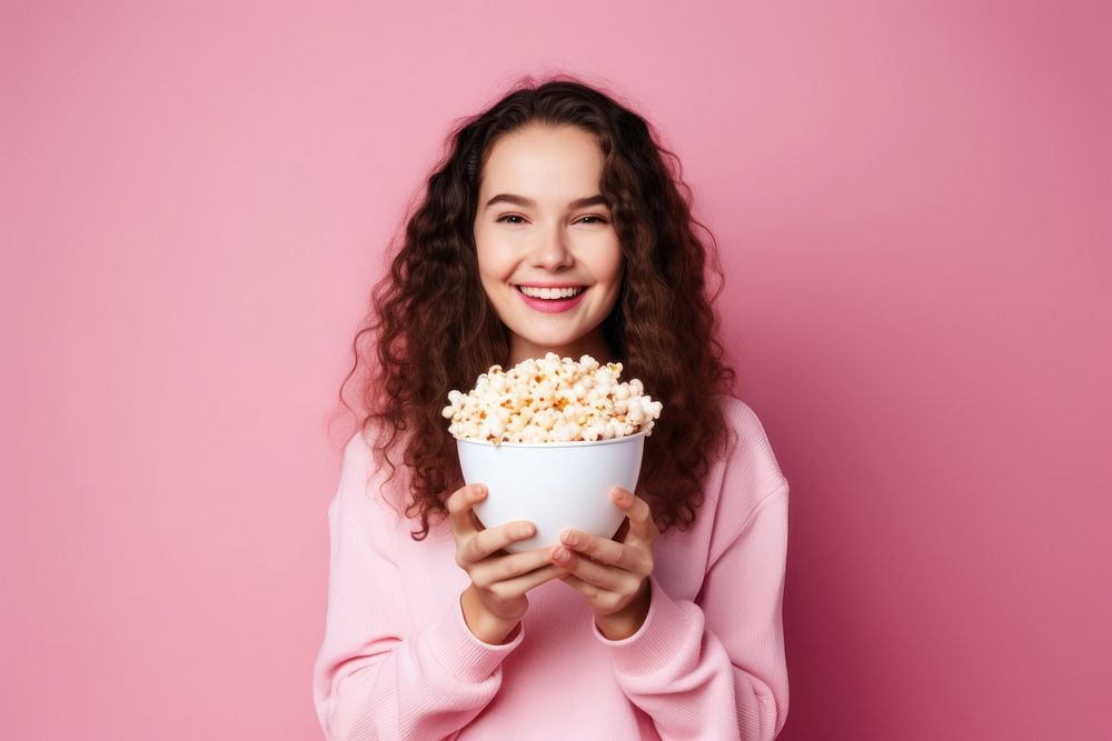 Photo of women holding popcorn on pink background adult smile happy.
