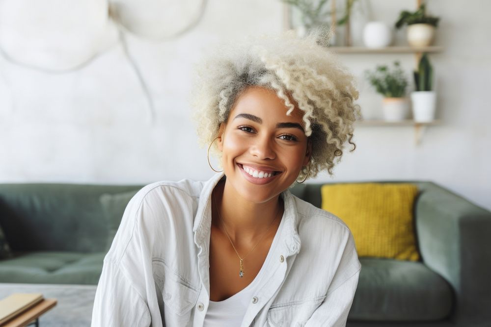 A black woman with white casual home attire mockup and bright hair color smiling accessories accessory necklace.