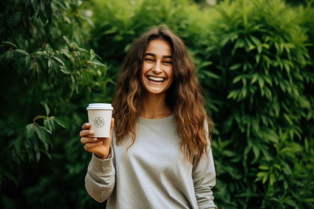 A happy woman holding cardboard coffee cup with handles smile laughing person.