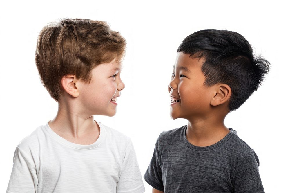 Asian boy and white boy smiling to each other child white background togetherness.