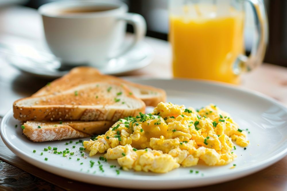 Breakfast with scrambled eggs brunch bread juice.
