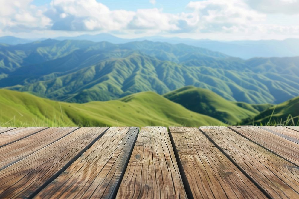 Wooden table background on a blur high green hills mountain wood countryside vegetation.