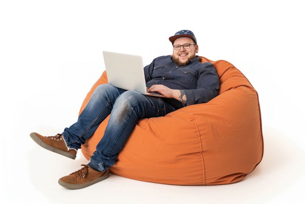 Cheerful chubby back man working on laptop seated on a minimal luxury color beanbag furniture computer adult.