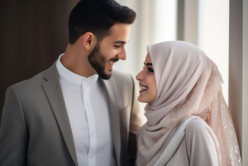 Muslim couple newlywed looking at each other happy bridegroom laughing.