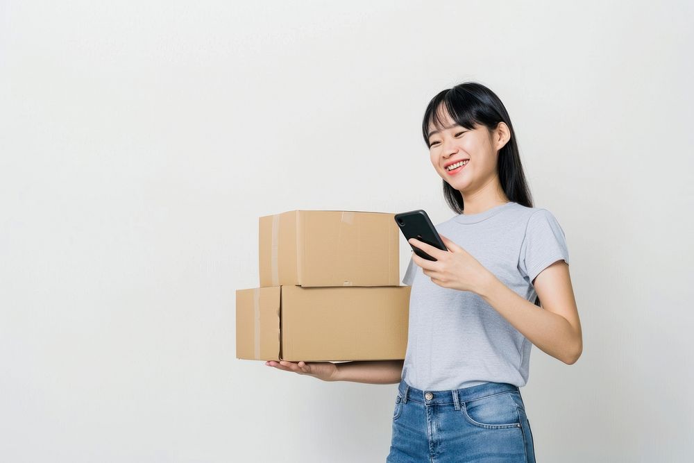Happy woman holding stack box cardboard white background mobile phone.