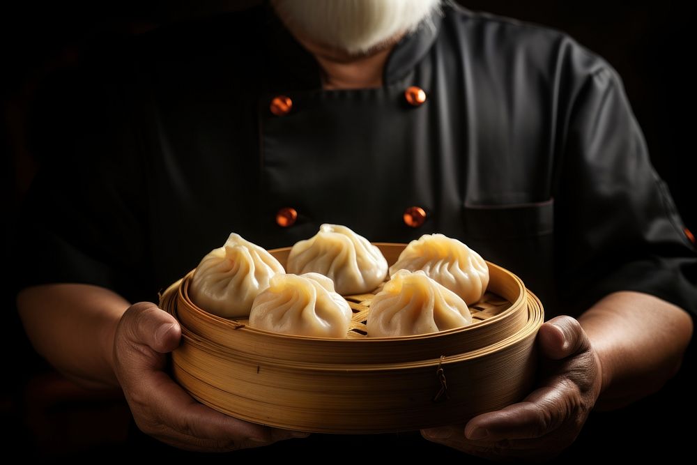 Chef holding a freshly cooked dimsum dumpling ravioli person.