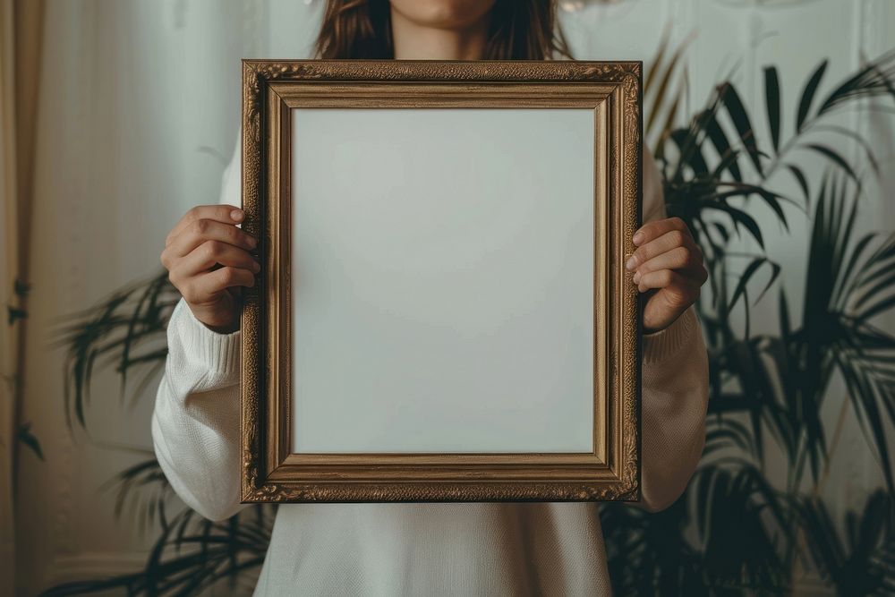 Holds an empty vintage photo frame mockup painting art.