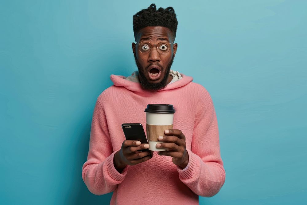 Black man holding phone and coffee cup surprised person human.