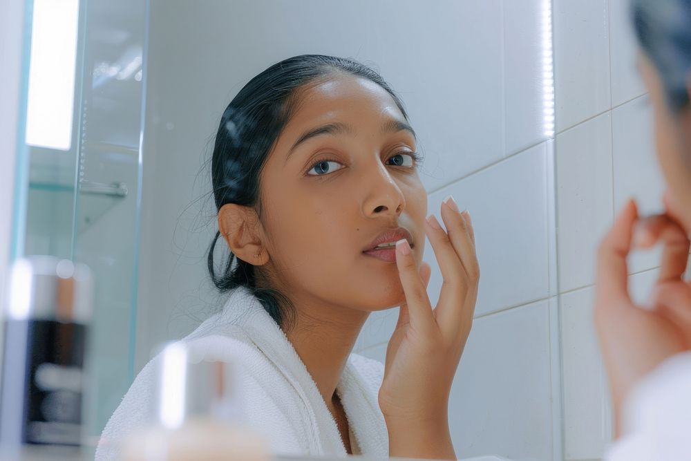 Indian woman applying skincare cosmetics person makeup.