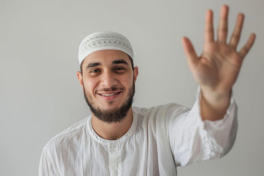Young muslim man waving hand smile photo photography.
