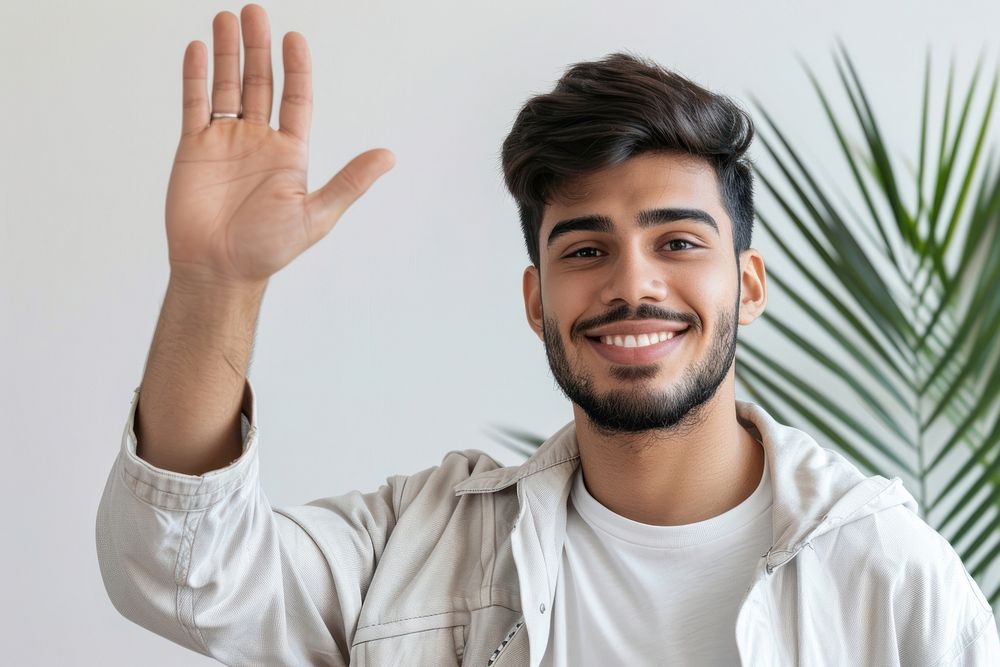 Young muslim man waving hand smile dimples person.