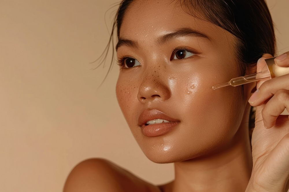 South East Asian woman applying facial serum drops skin cosmetics female.