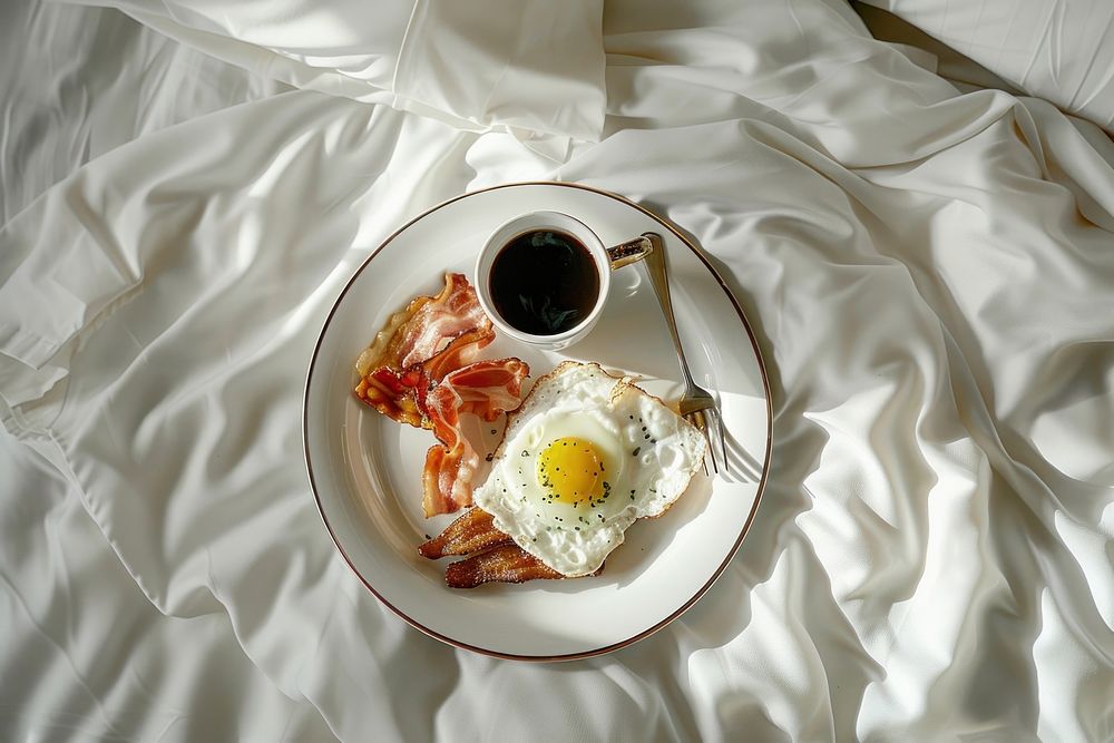 A luxury hotel bed with a breakfast tray food egg brunch.