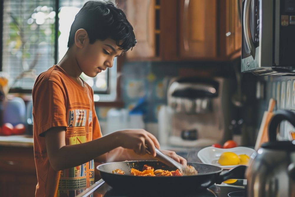 South Asian boy cooking food appliance.