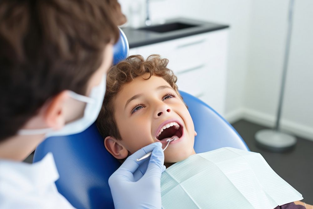 Close up of boy having his teeth examined by a dentist toothbrush clothing apparel.