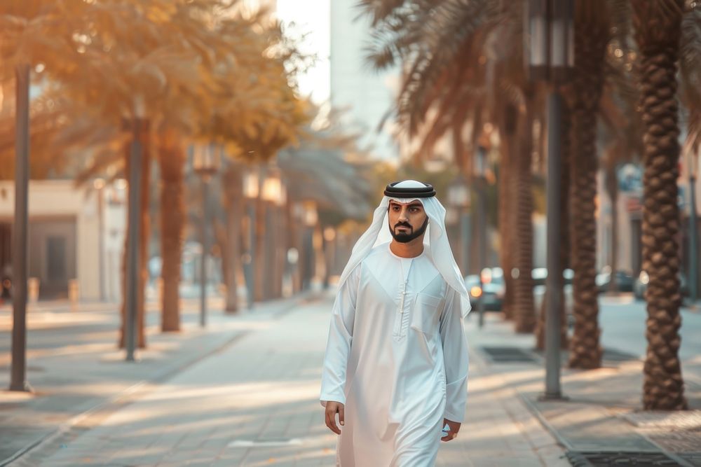 Arab Middle Eastern man wearing emirati kandora traditional clothing in the city pedestrian standing people.
