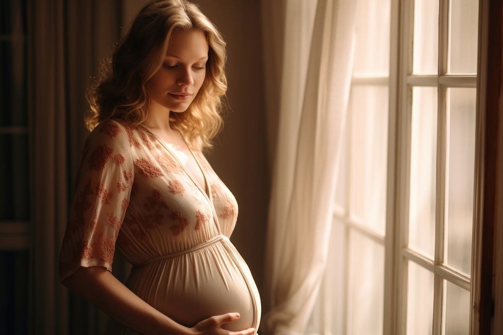 Beautiful pregnant woman standing near window at home photo photography portrait.