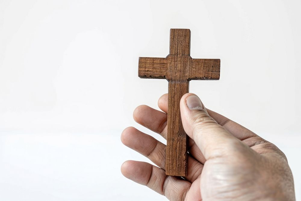 Hand holding a cross hardwood symbol.