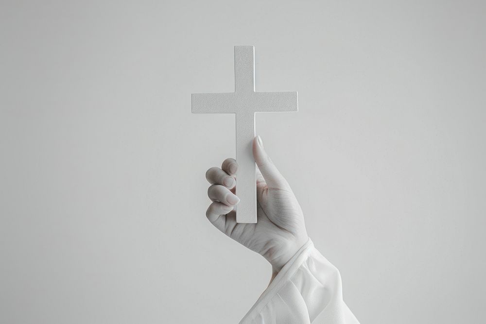 Hand holding a cross clothing apparel symbol.