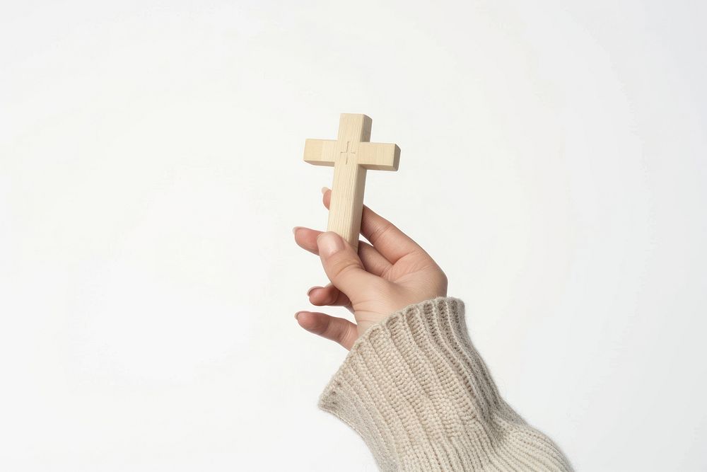 Hand holding a cross symbol.